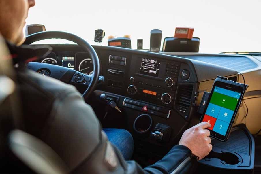 Voznik v kabini tovornjaka uporablja tablico z elektronskimi dokumenti